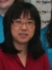 Dr. Ann K. Miyamura wearing a red shirt in her practice
